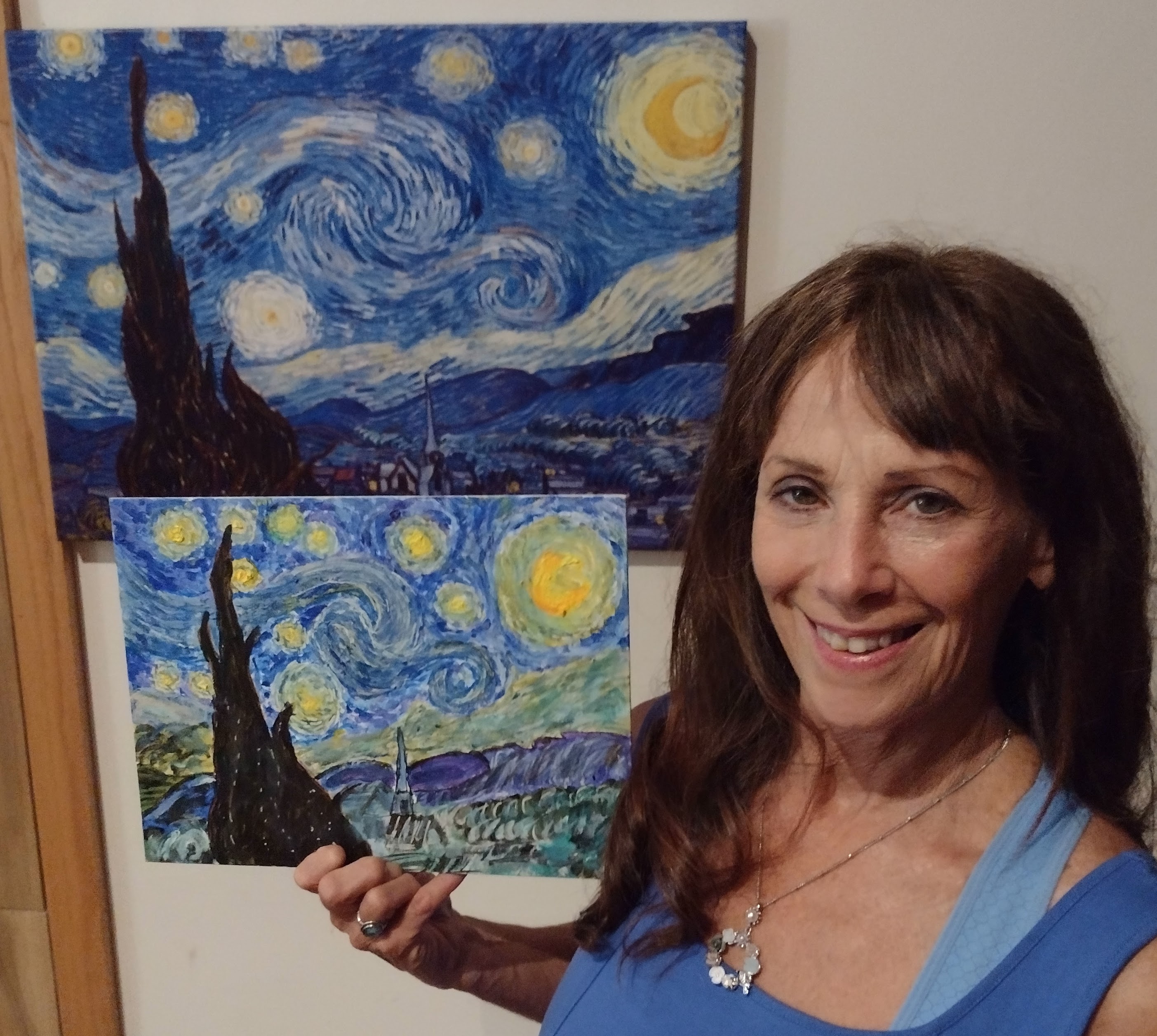 brunette painter standing in front of vivid starry night painting 