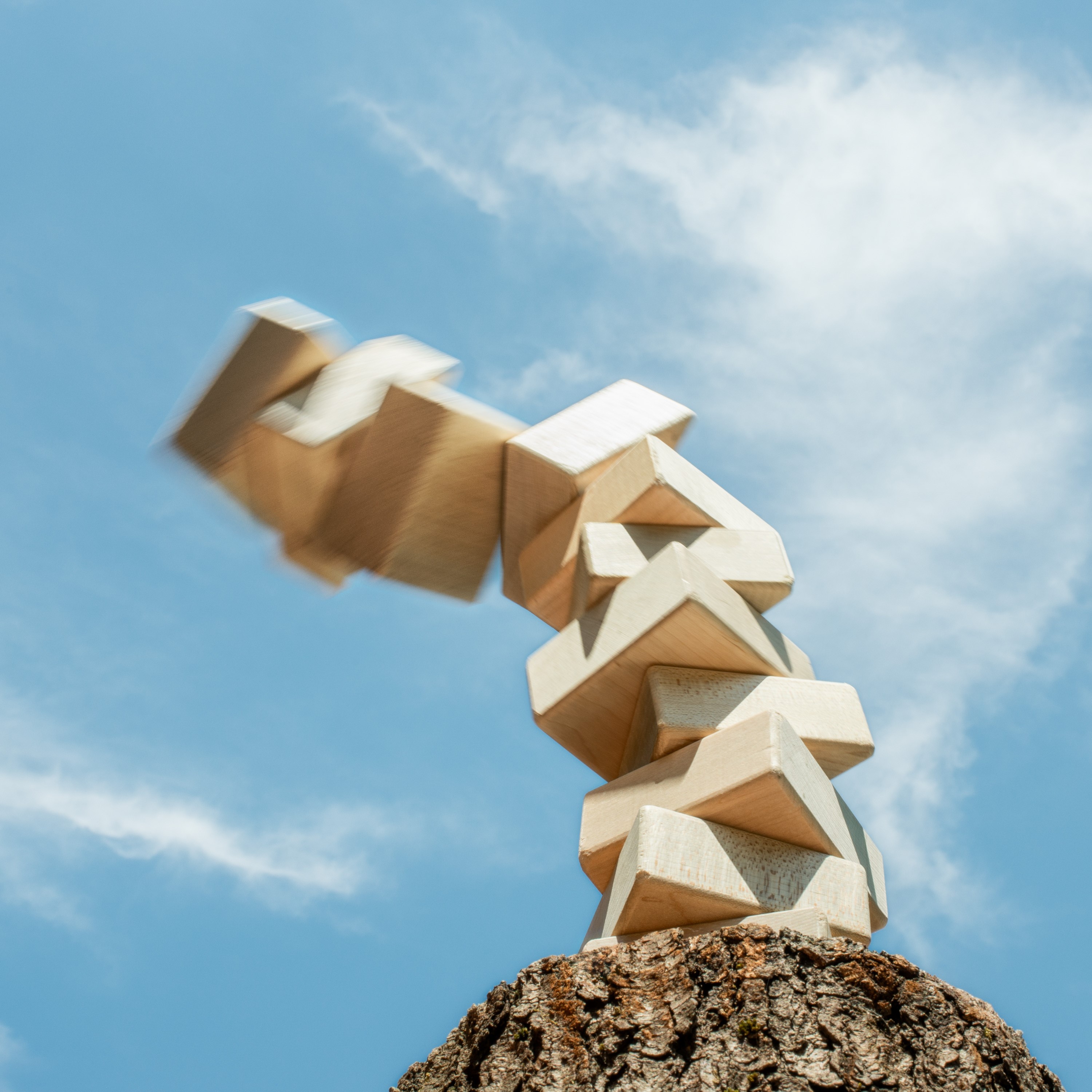 Tower of natural blocks precariously reaching toward blue sky