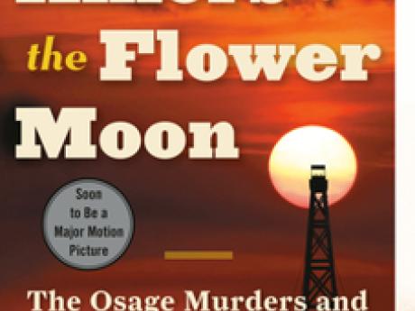 Cover of the book "Killers of the Flower Moon," a setting sun against a red sky with an oil derrick in the foreground
