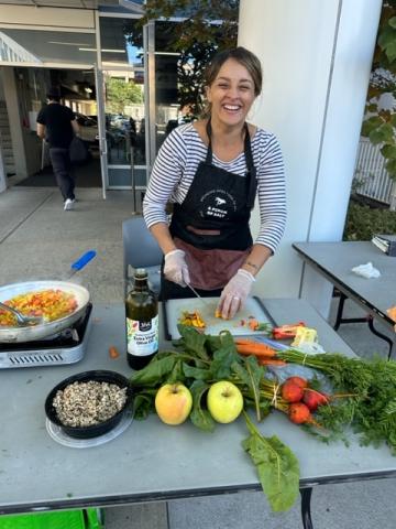 Woman wearing apron and smiling while cooking fresh food