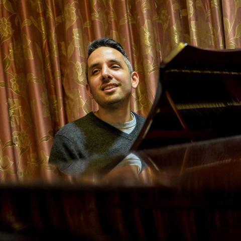 Gil Harel behind a piano